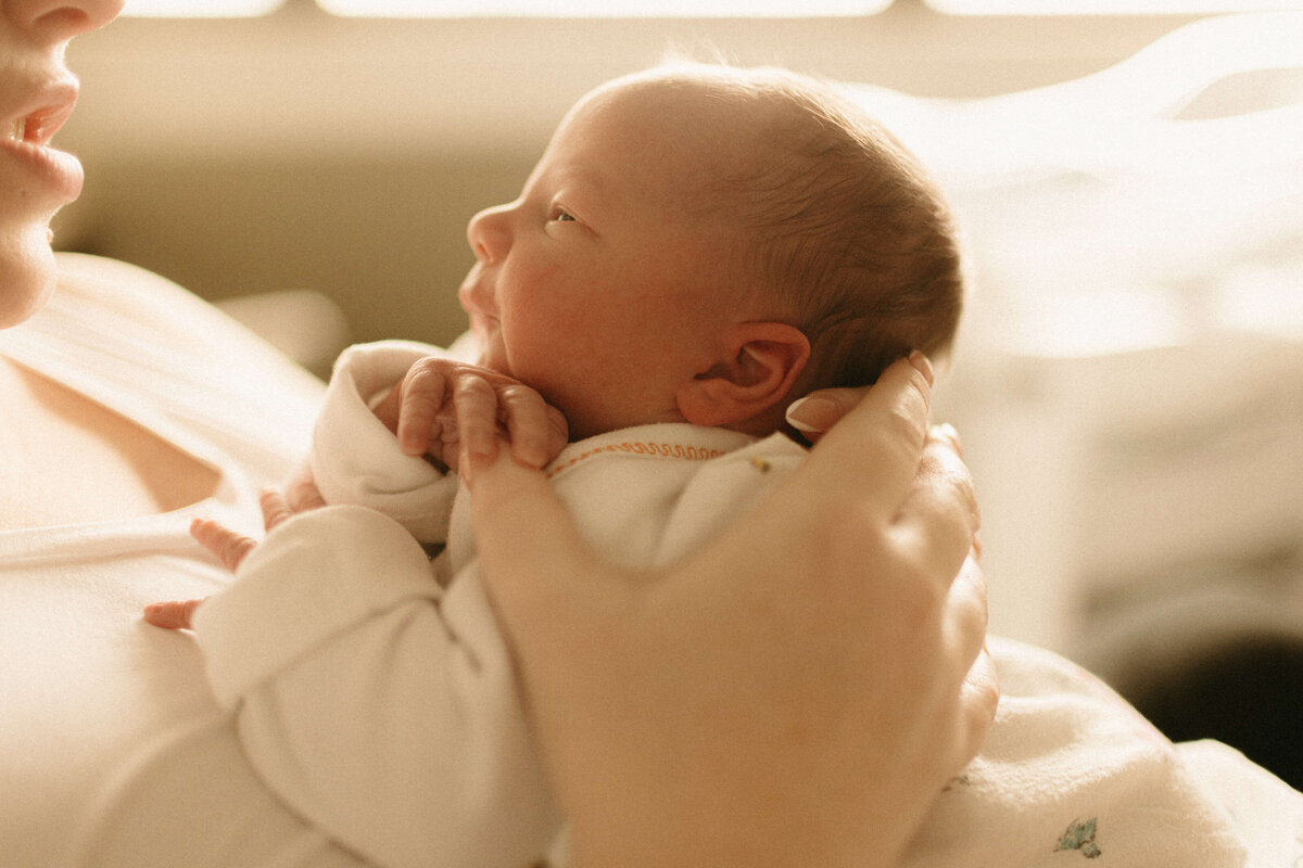Close-up of newborn’s tiny hand holding parent’s finger in Nashville hospital.