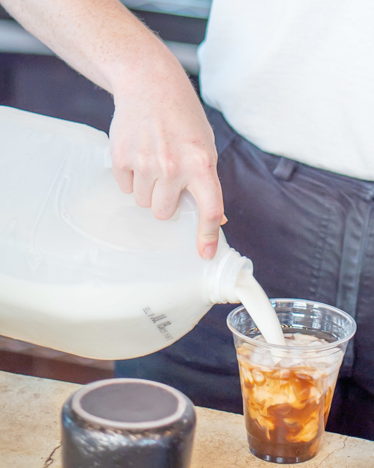 Milk being poured into a cup of coffee