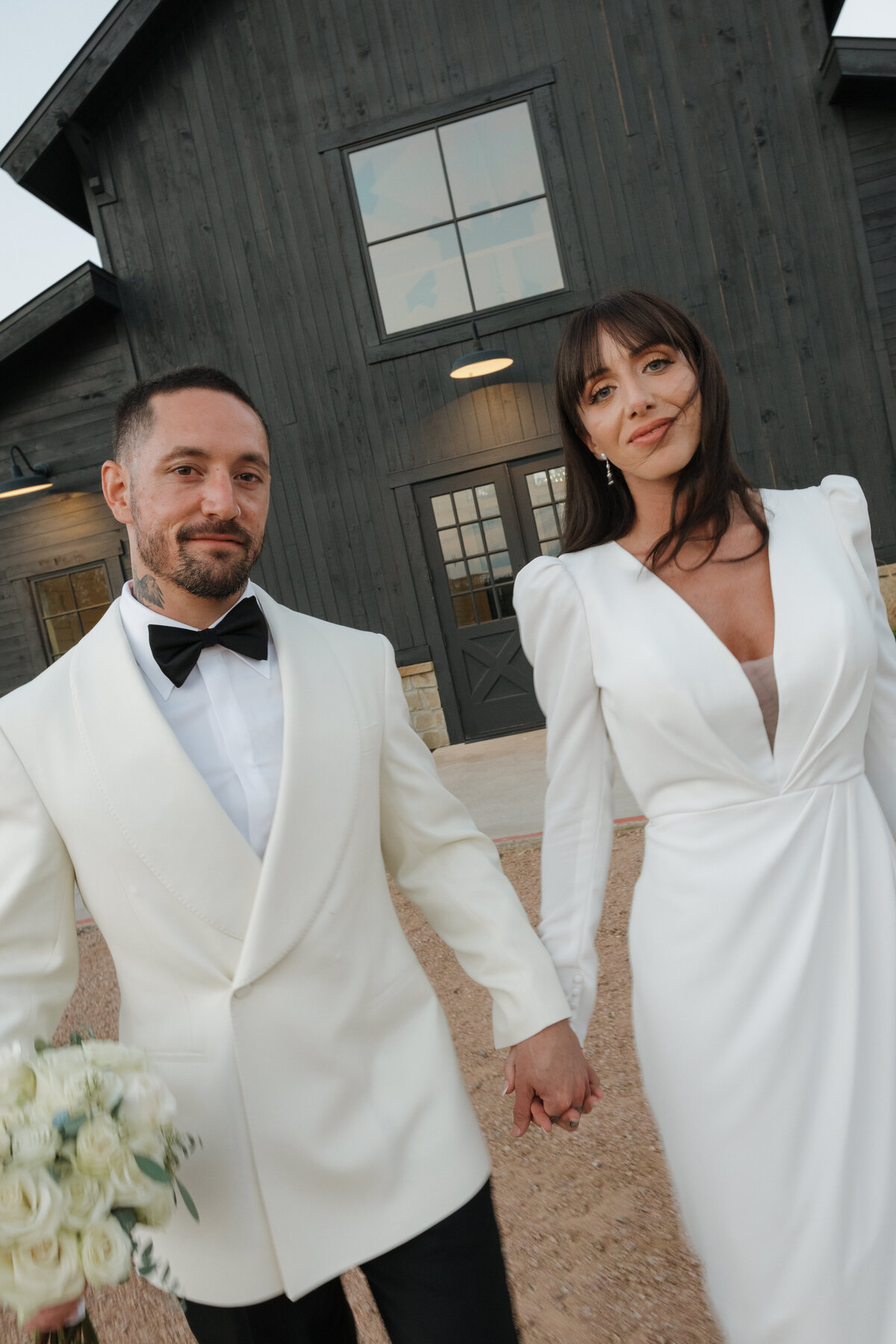 A bride and groom walking towards the camera smiling at Morgan Creek Barn.