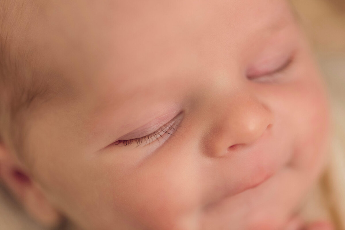 Close-up of a sleeping baby's face, showing closed eyes and a peaceful expression.