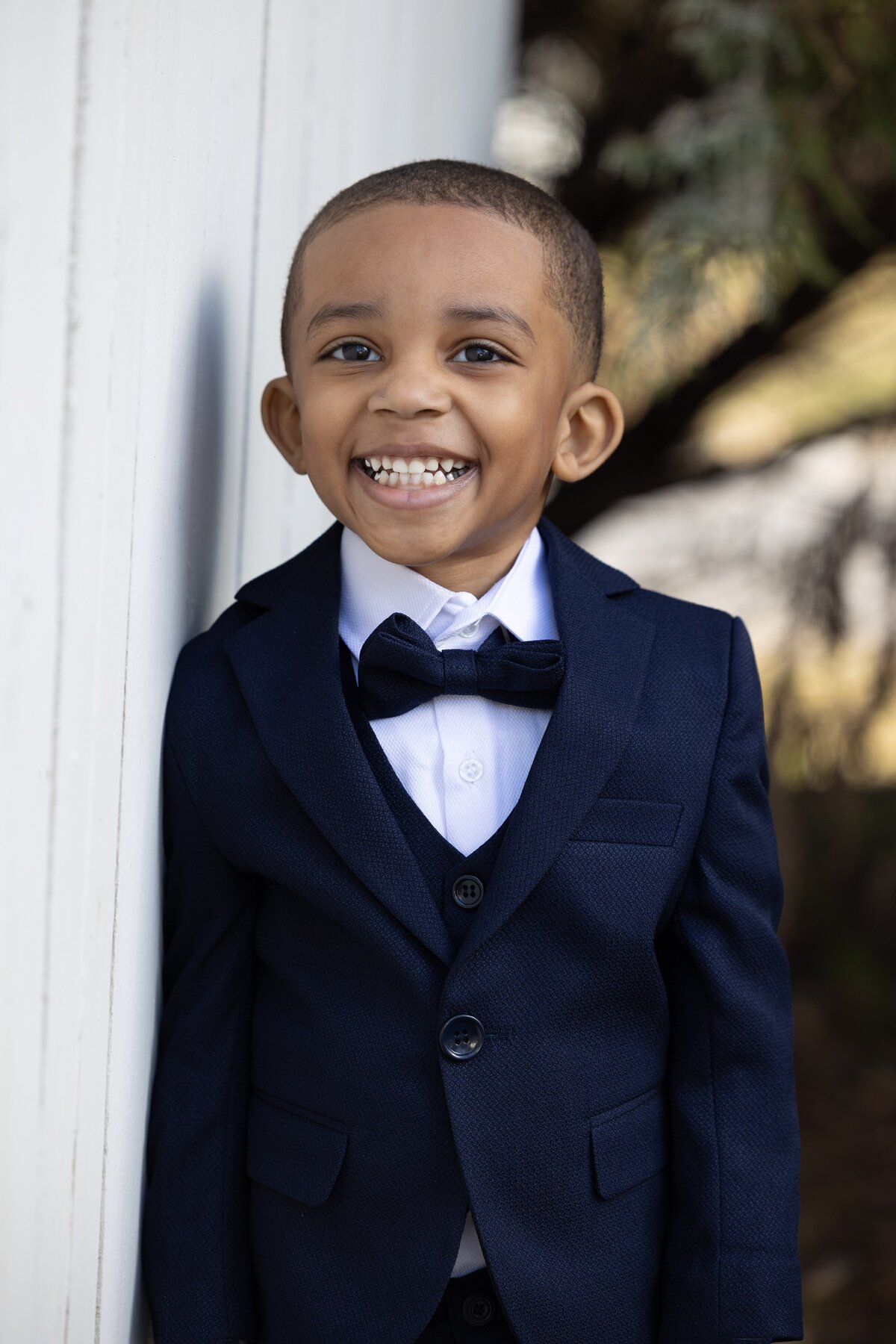 a boy in a navy suit smiling