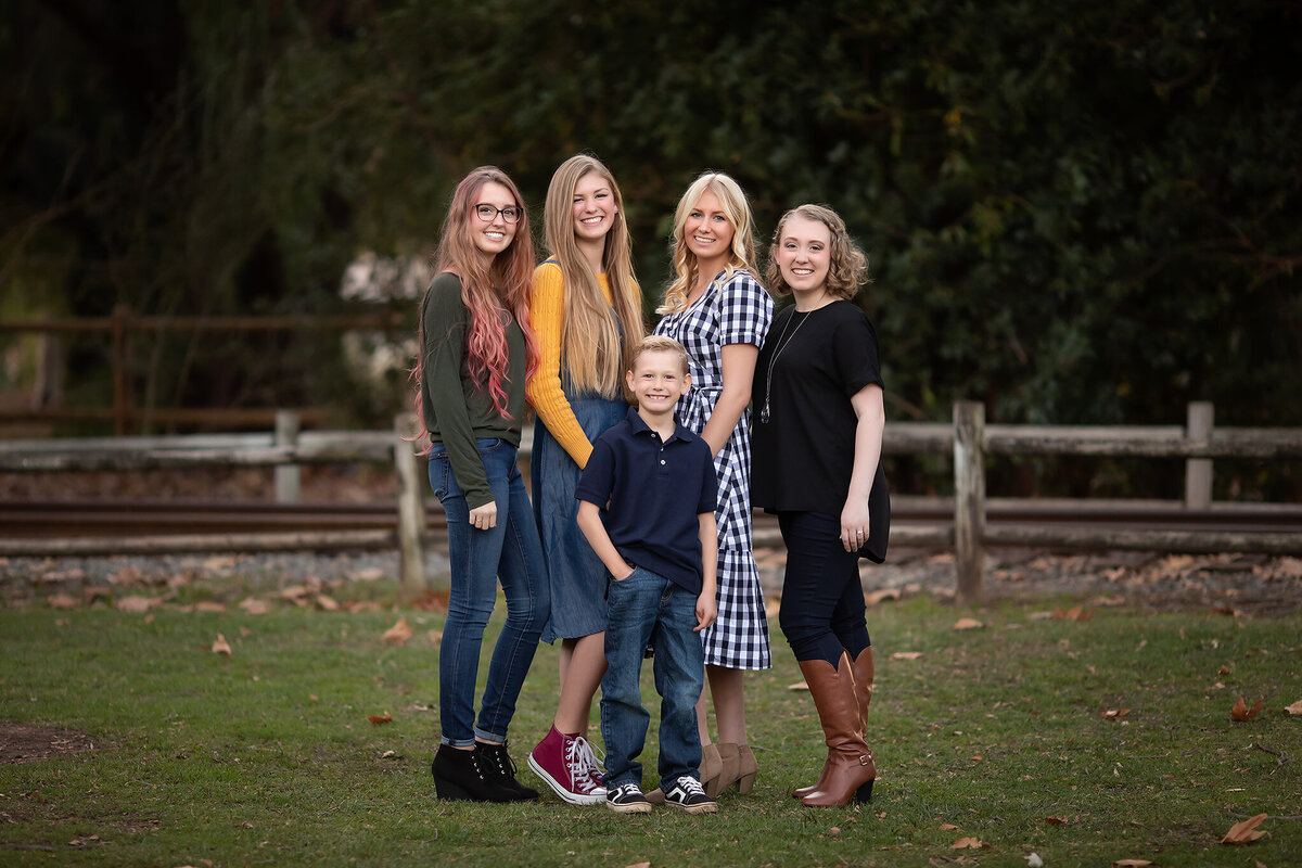 Family smiling outdoors, enjoying a beautiful fall day. Dallas family photographers capturing happy moments.