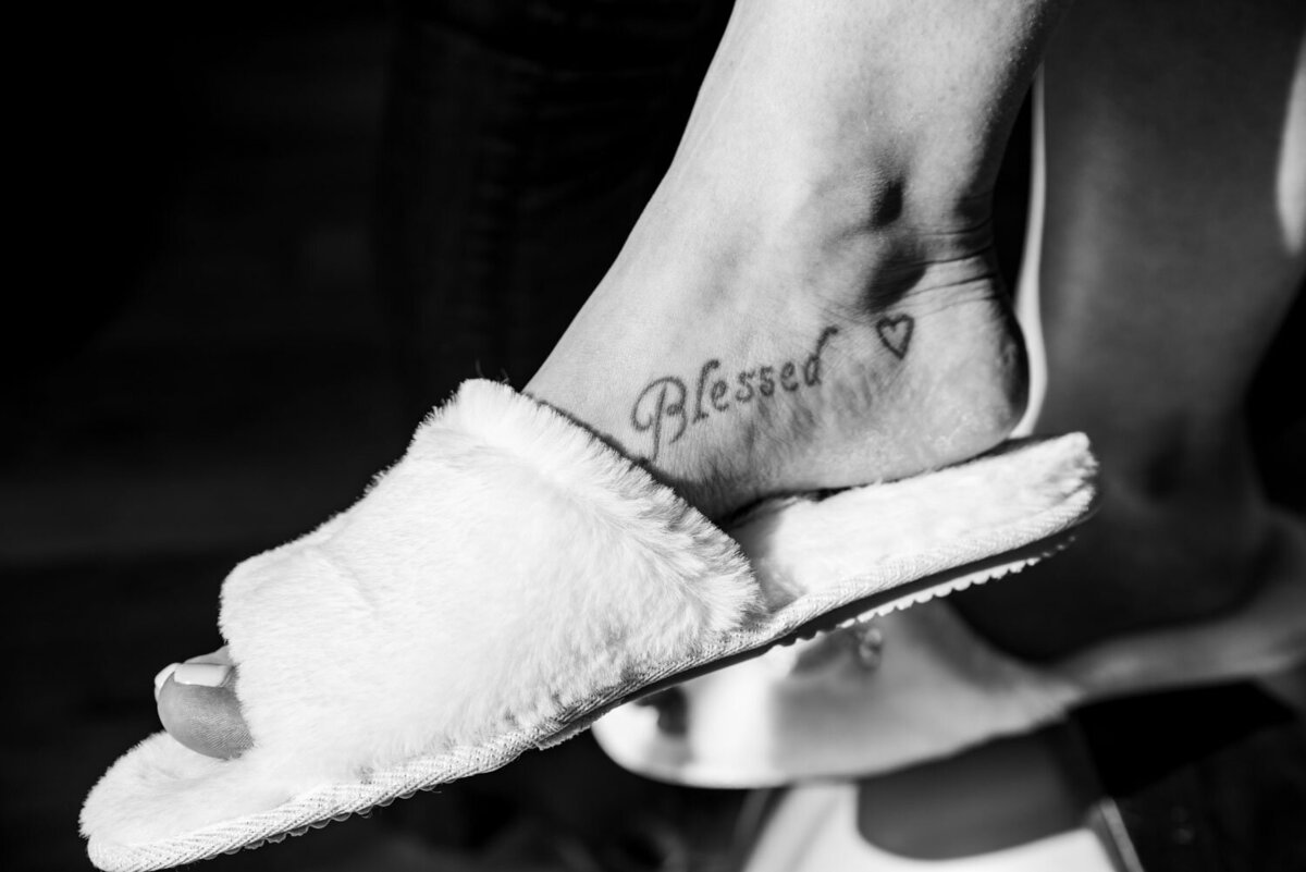 A woman has a tattoo on her foot that says blessed