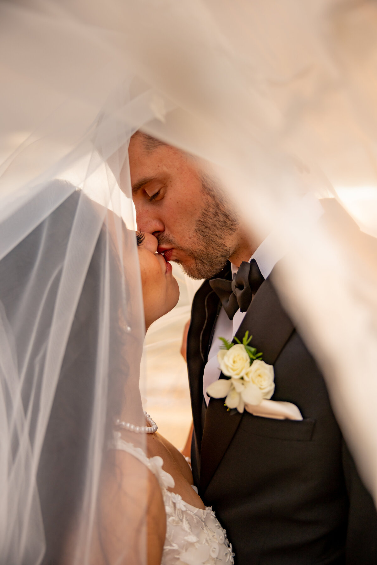 Maui Wedding Photographer captures groom kissing bride under veil