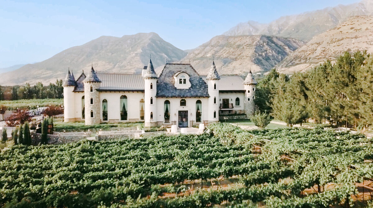 Wadley Farms Utah Drone shot by Cali Warner Media, wedding venue with vinyard in front of castle and mountains in the backdrop
