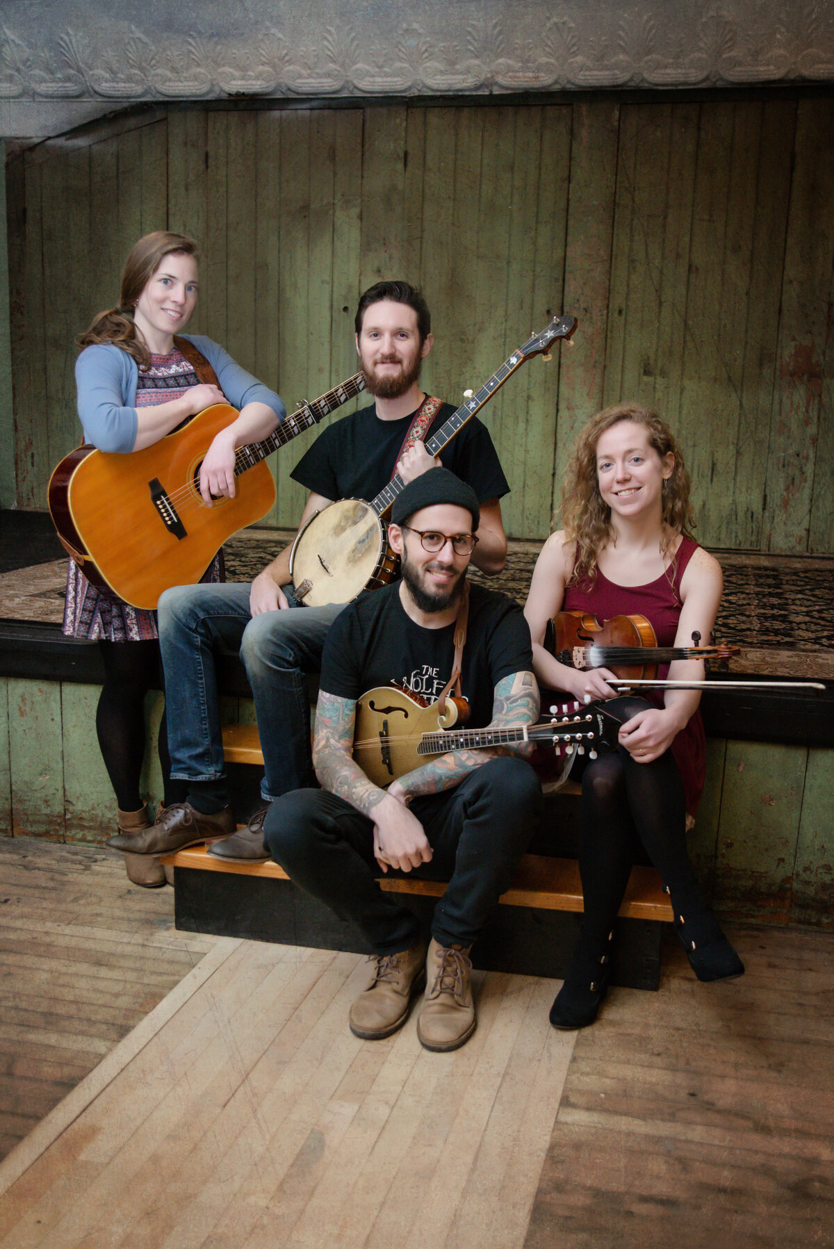 A band of four posing with their instruments