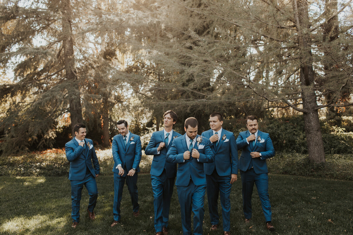 men in blue suits walking on grass