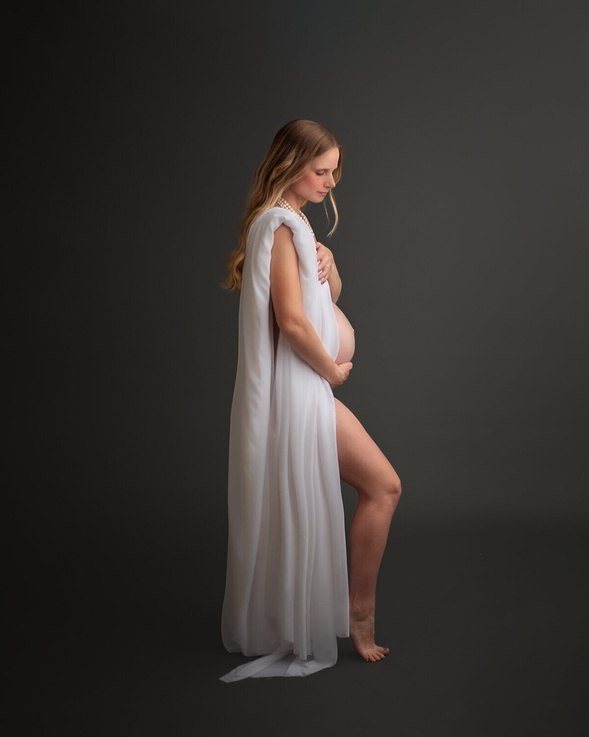 pregnant woman with draped fabric at maternity photos by sutherland photography