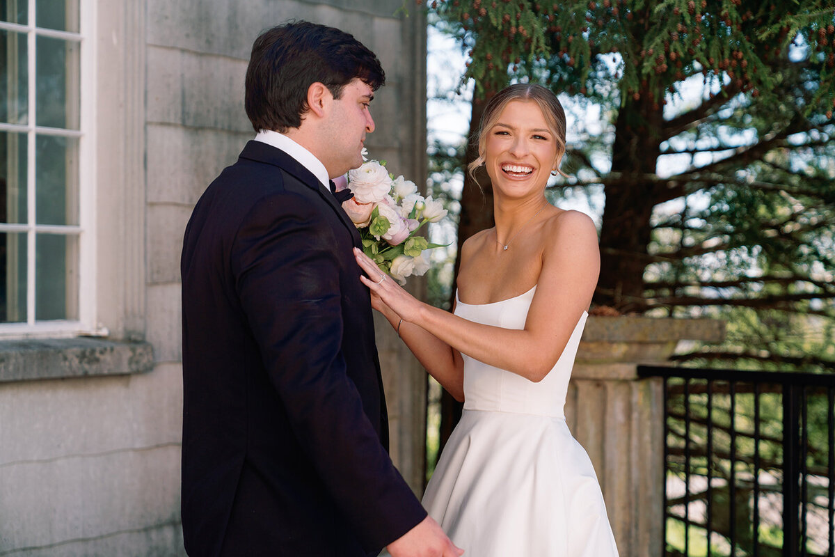 Bride laughing and holding the groom’s arm during their first look at Burritt on the Mountain in Huntsville, Alabama, captured by wedding photographer Perry Hancock.