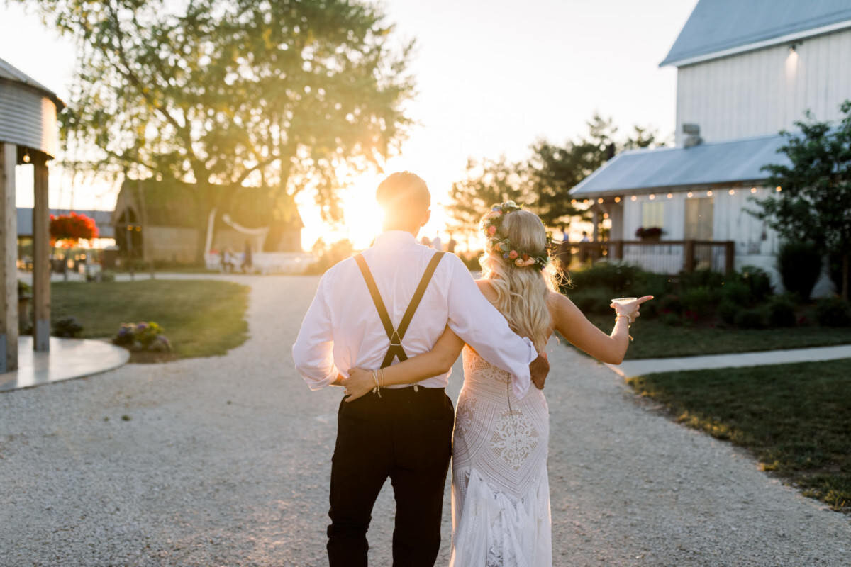 Bride and groom walk into the sunset at their wedding