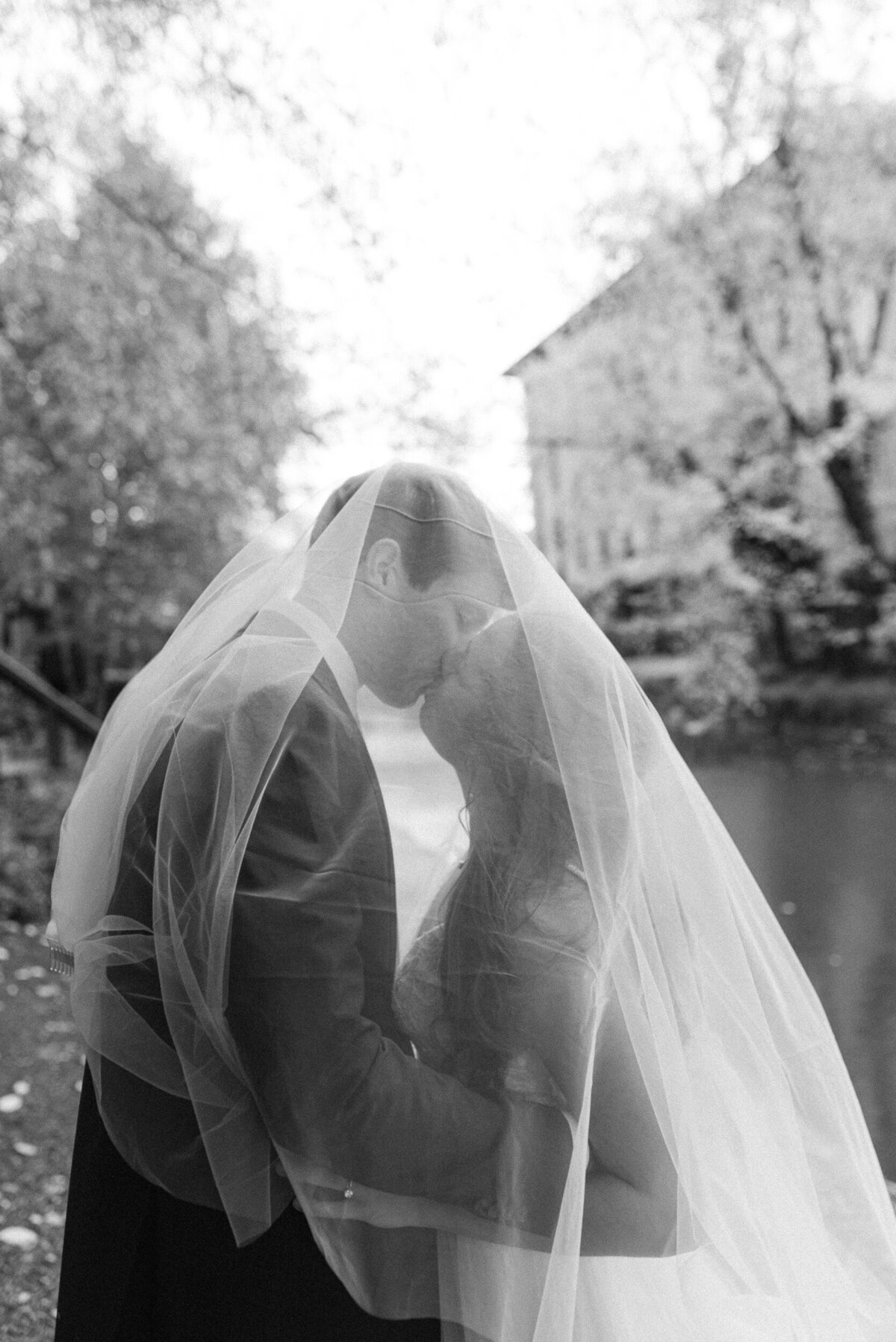black and white image of bride and groom under veil kissing washington dc fine art wedding photography