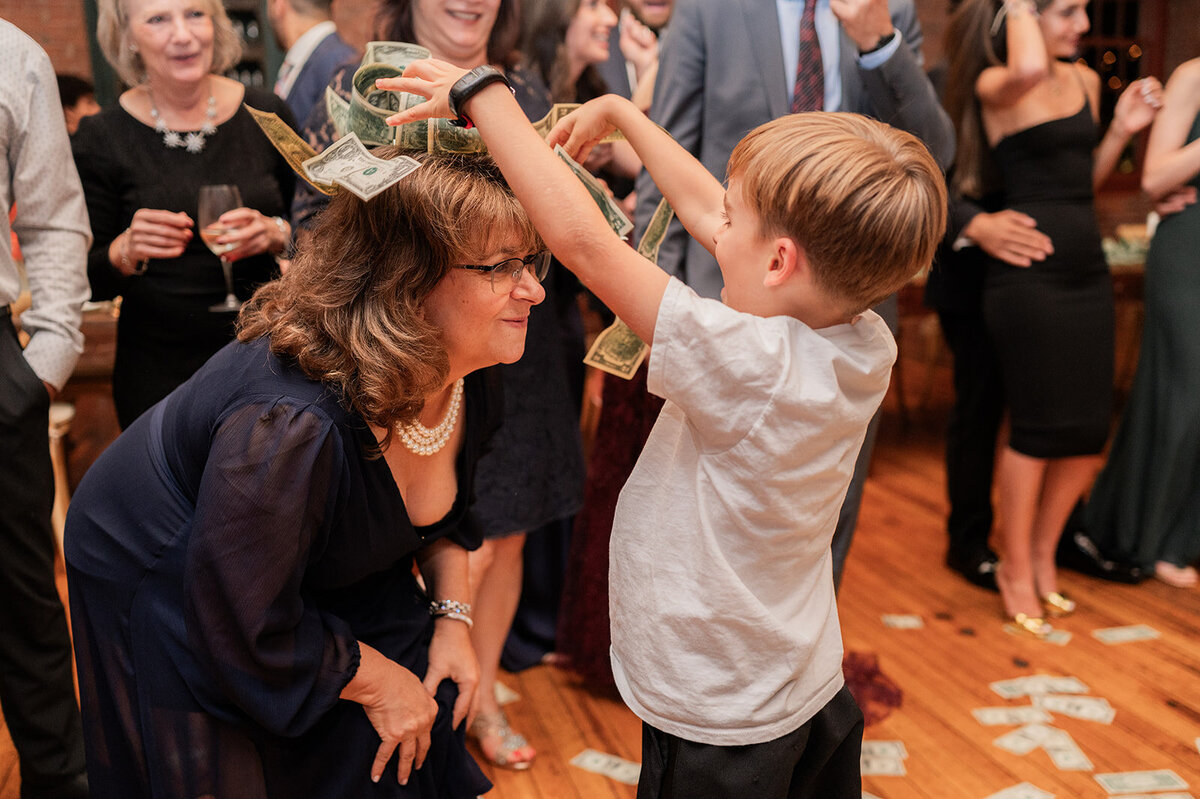 child has fun tossing money during wedding reception