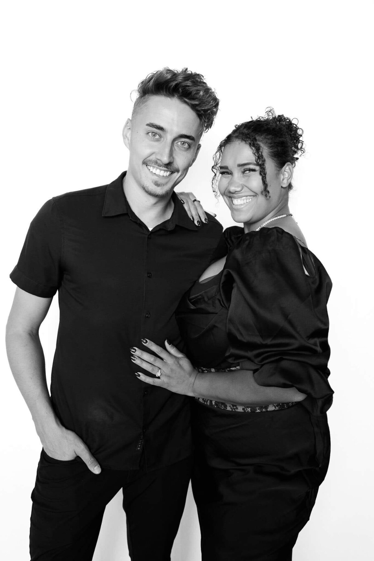 A smiling couple posing together in a sleek black and white image captured by Monochrome Portraits, a modern Phoenix photo booth experience.