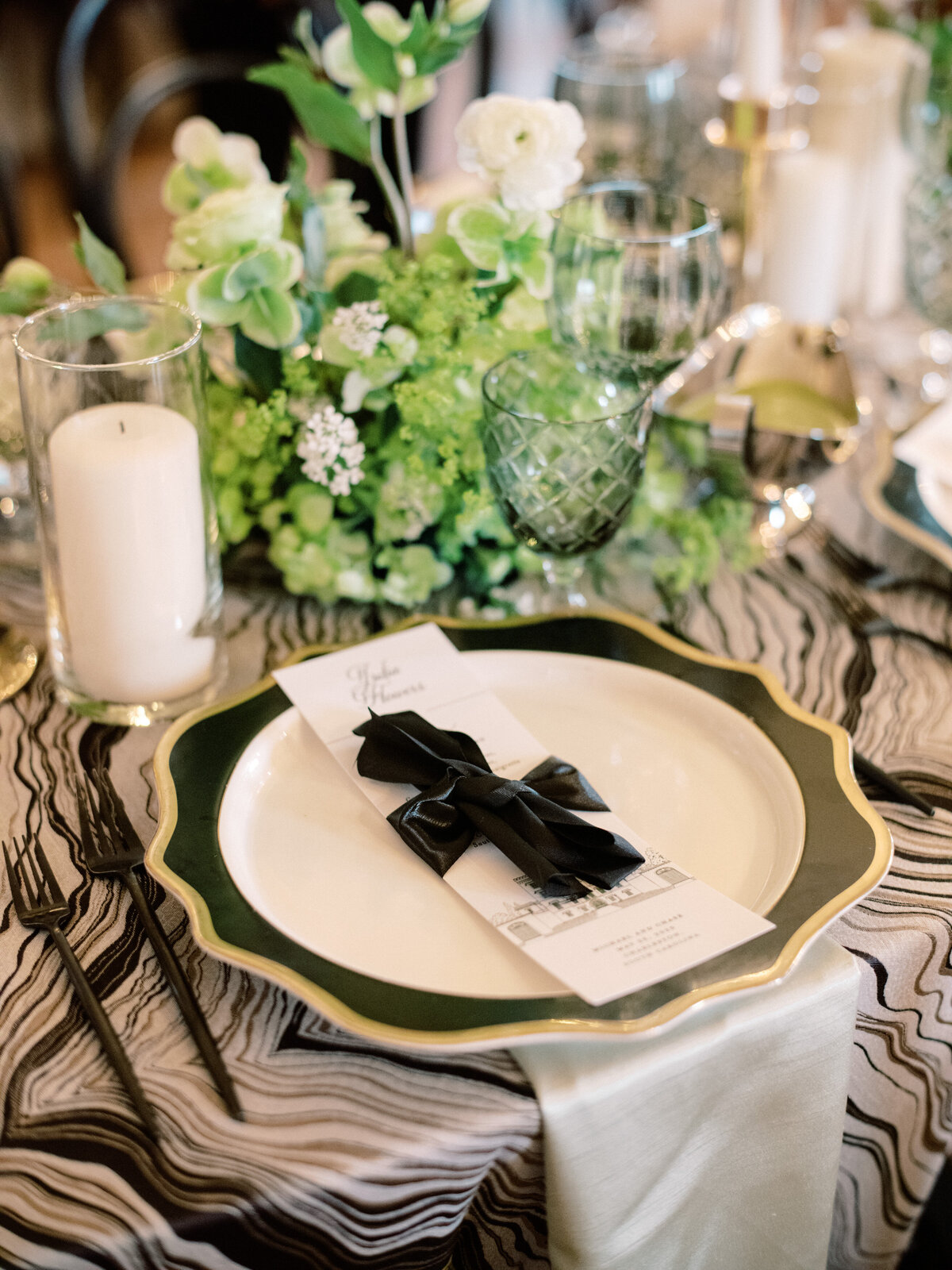 An elegant table setting featuring a sophisticated place decor with a black ribbon accent, showcasing refined taste and attention to detail for an upscale wedding experience.
