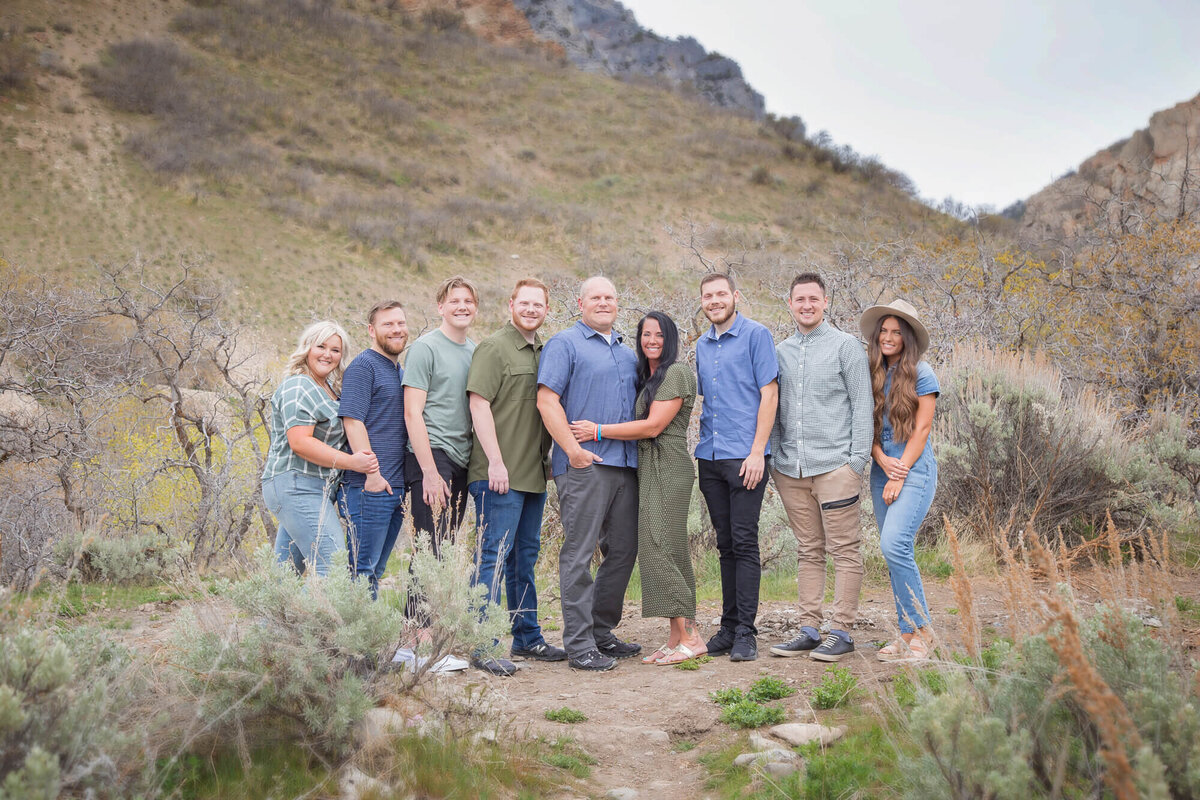 Family of adults in Rock Canyon Park posing for a portrait wearing denim blue and greens