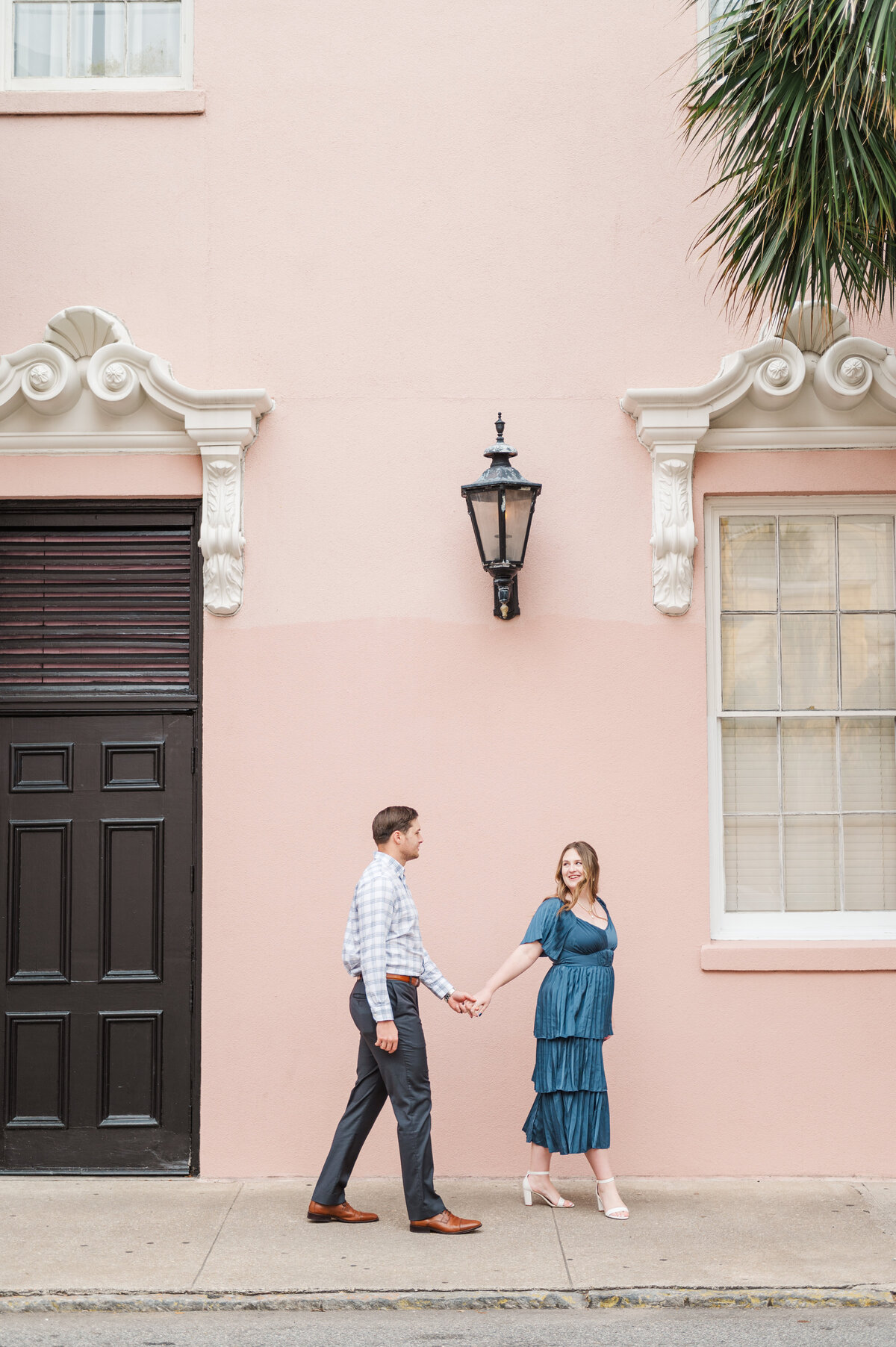 couple walking holding hands through the streets of charleston
