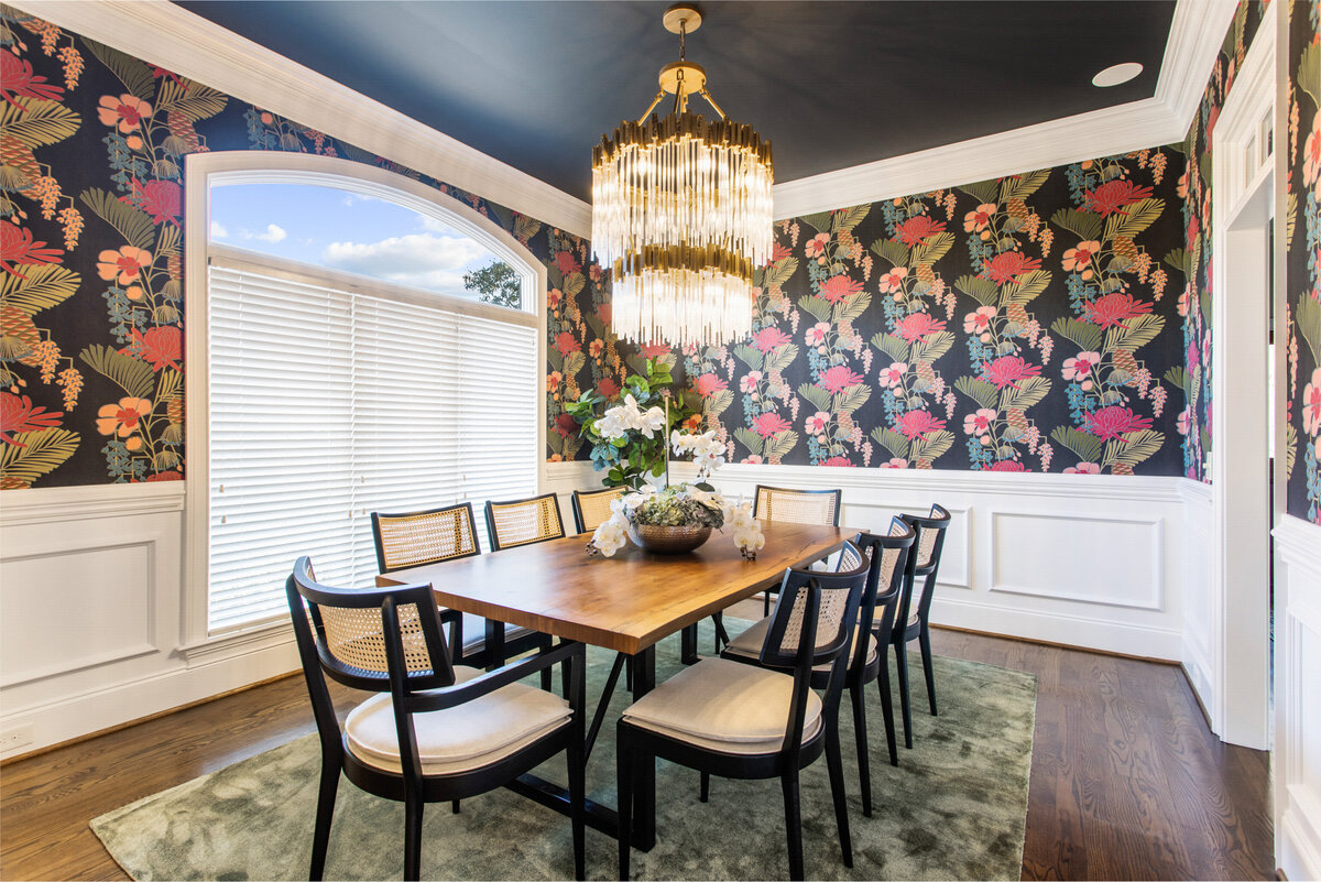 colorful dining room with flowered wallpaper and a green accent rug
