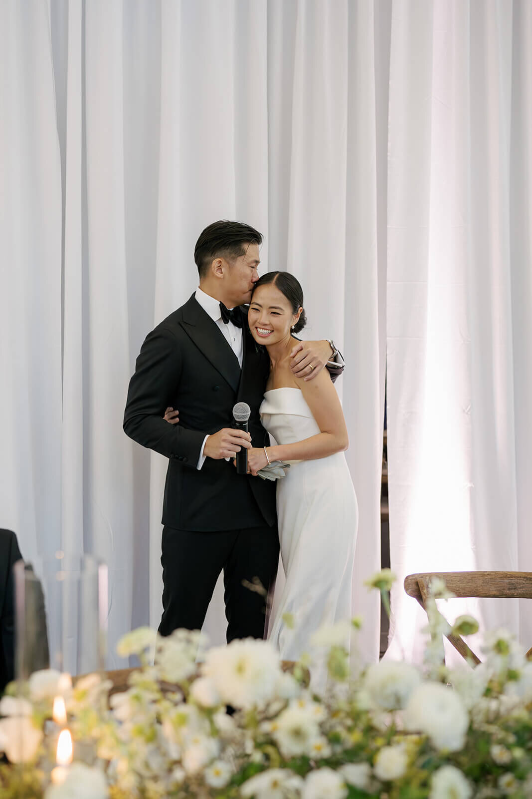 Bride and groom share a hug after speeches conclude at the Aspen Meadows Resort reception venue in Colorado.