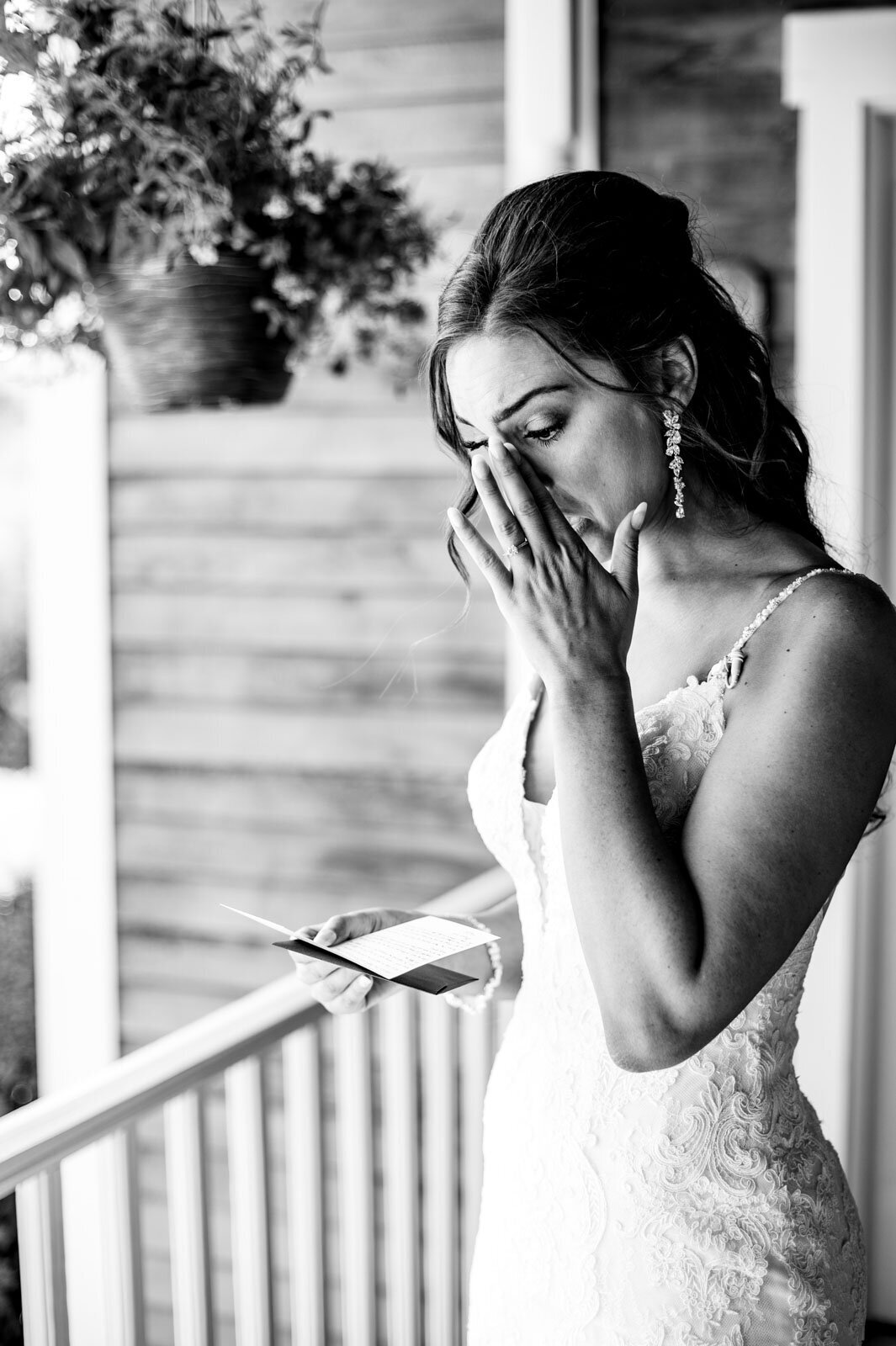 black and white bride reading card from groom with tears at vermont farm wedding
