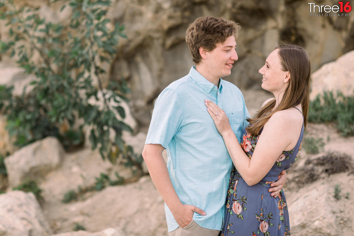 Engaged couple gaze into each other's eyes during photo session