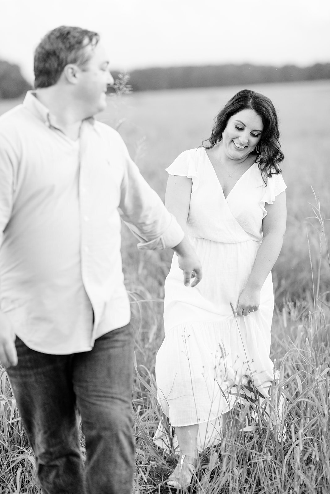 Engagement portraits of couple in field at Hamilton Place Pursell Farms