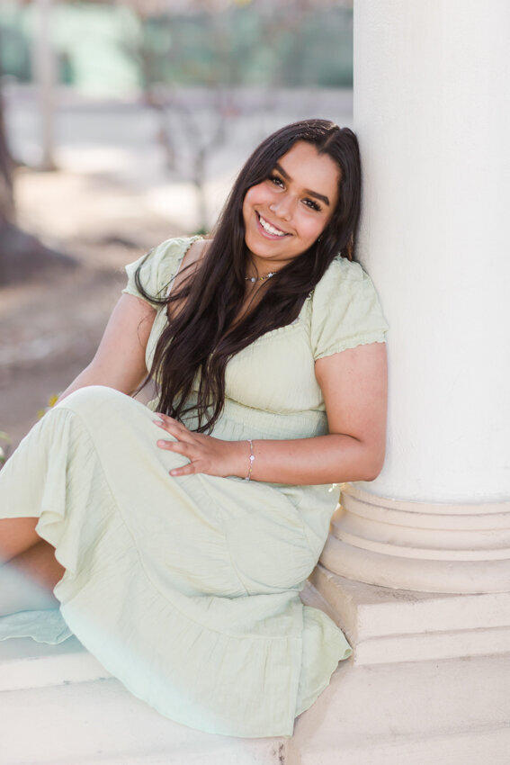 Senior girl leaning against pillar Balboa Park San Diego