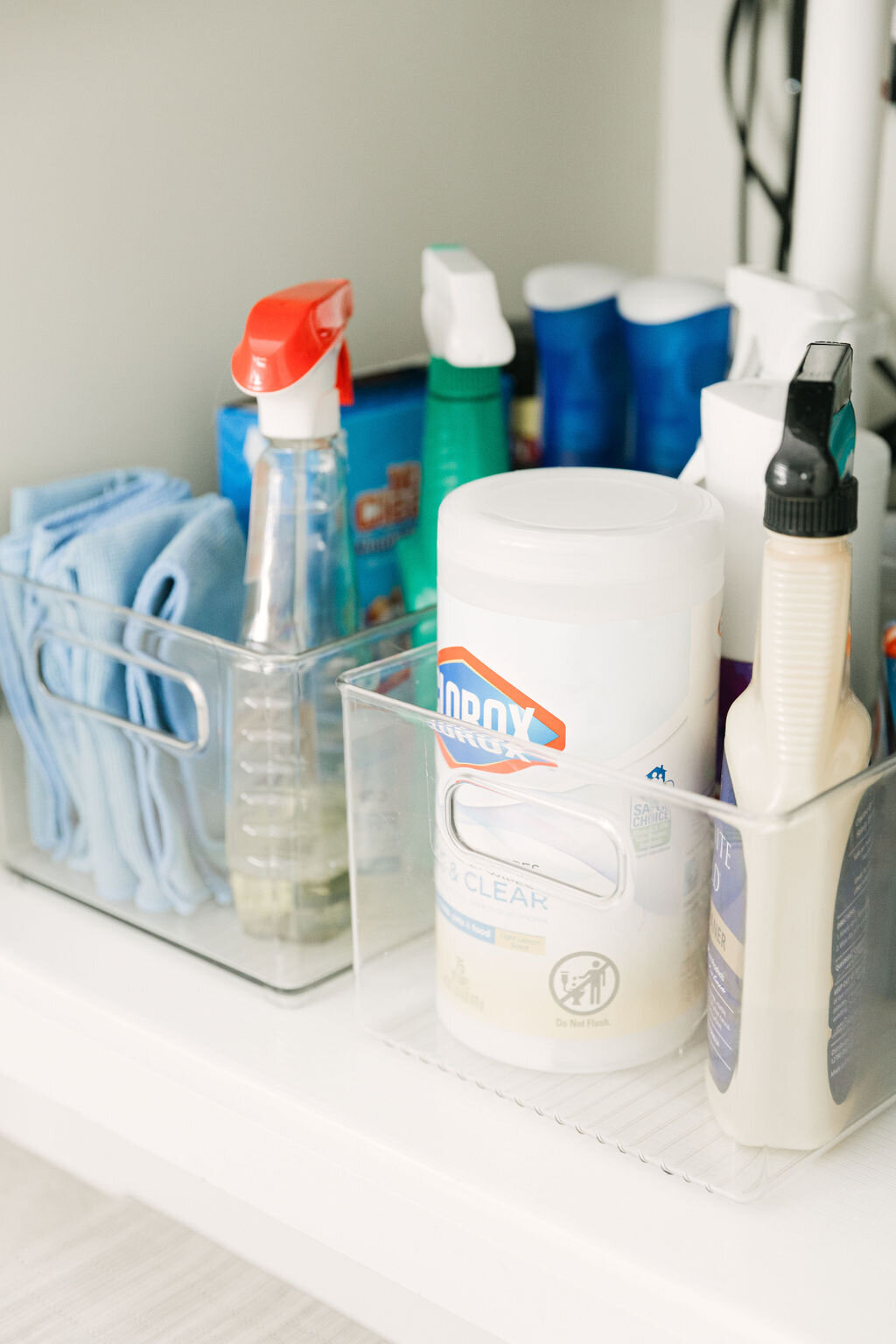 Clear bins for organizing cleaning and laundry supplies