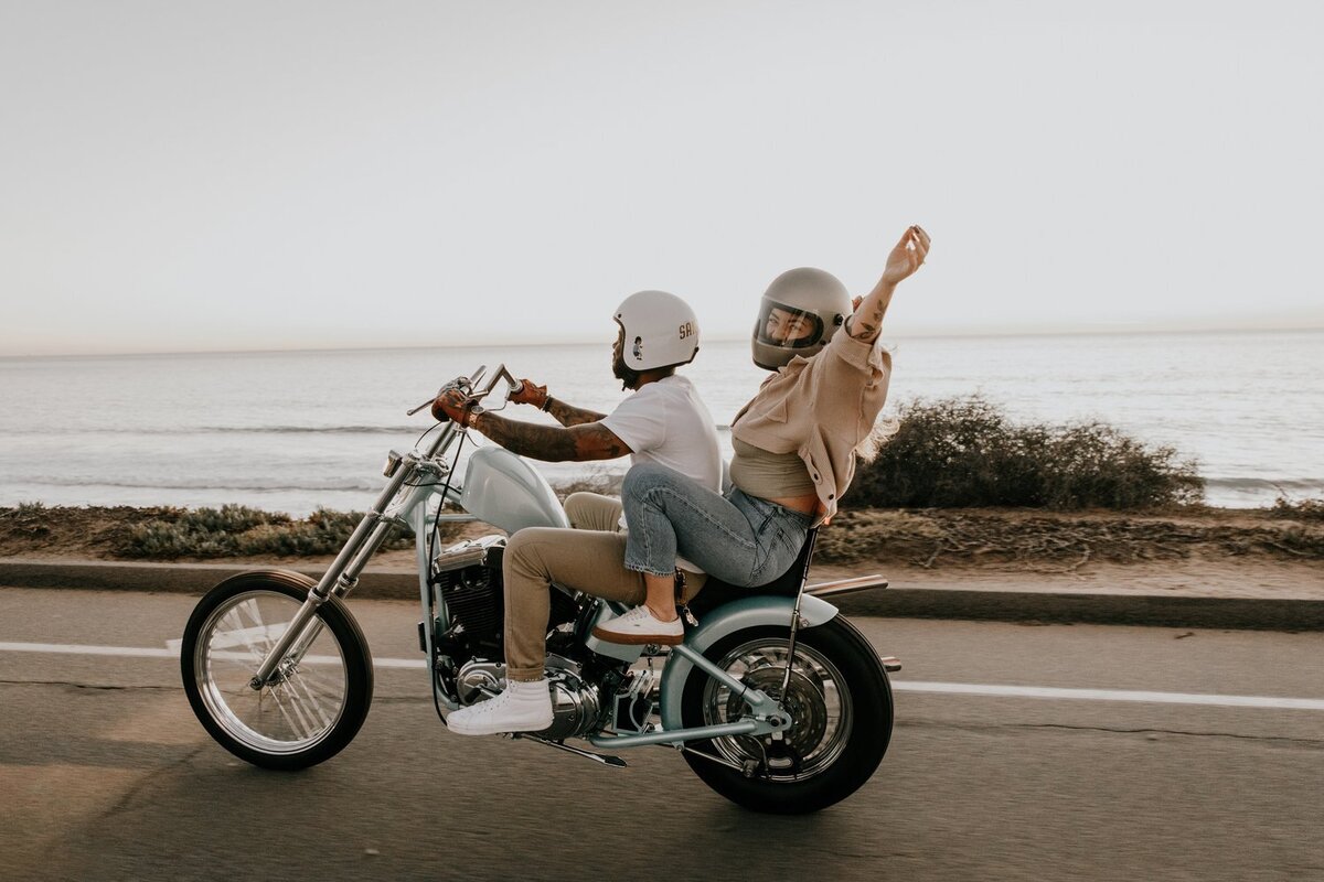 couple poses on motorcycle for engagement photos in san diego
