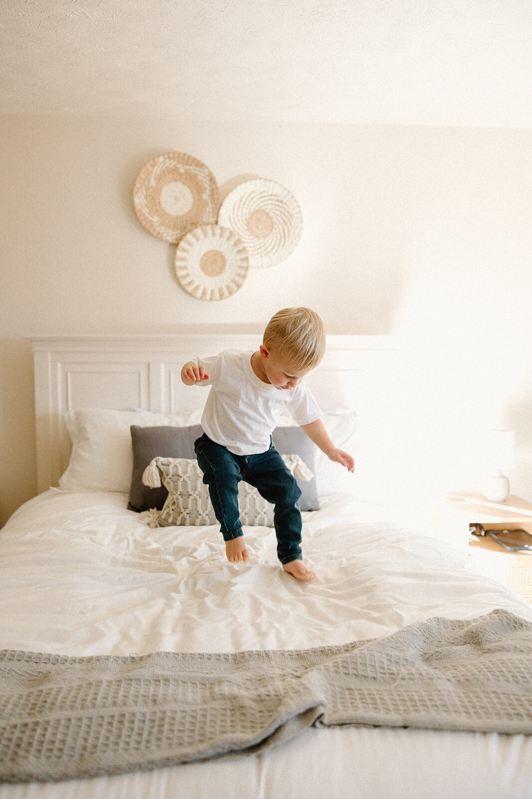 little boy jumping on bed during in home family photos