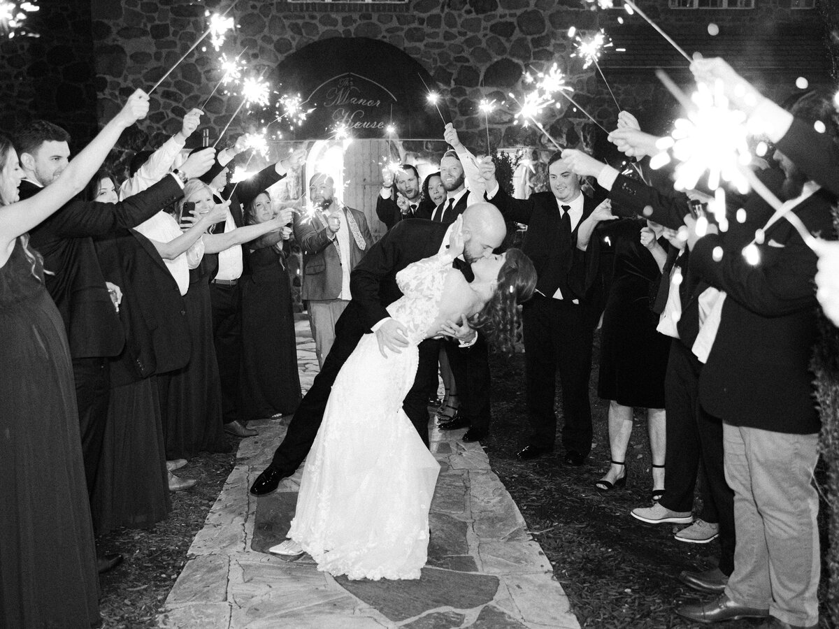 A bride and groom share a kiss during their sparkler exit at poplar spring manor