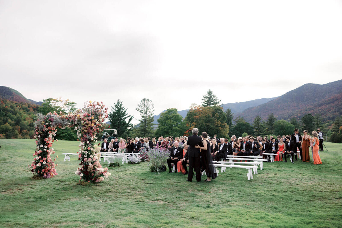 The wedding guests are seated at the beautiful wedding ceremony set-up outdoors at The Ausable Club, NY. Image by Jenny Fu Studio.