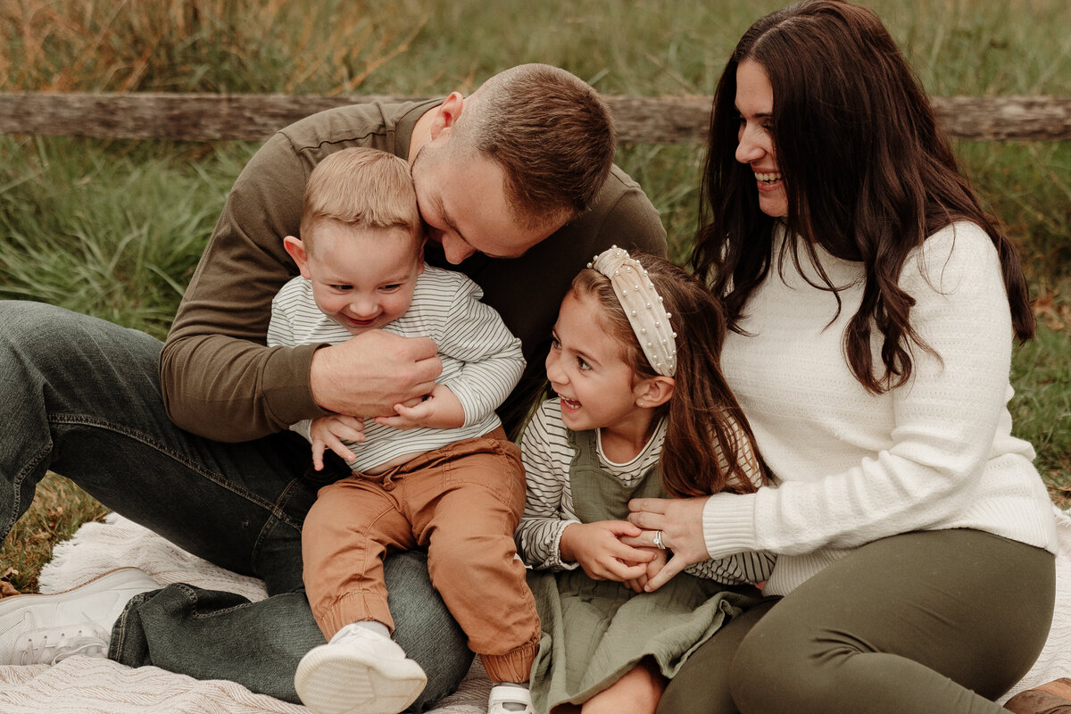 Family sitting in a field laughing