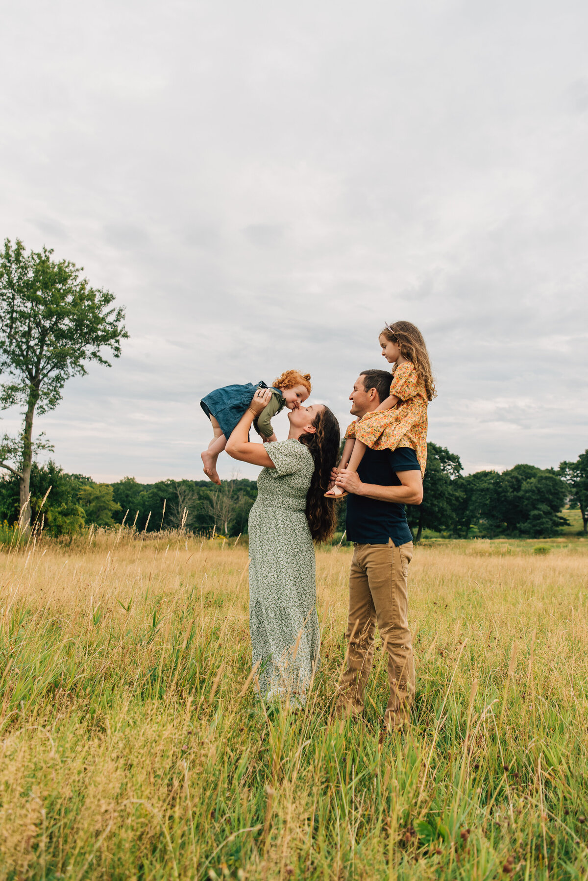 Family of four playing in field