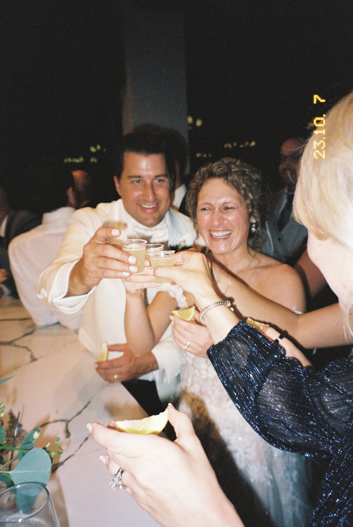 film image of bride and groom clinking their shots together before taking a drink taken by Mansfield Wedding Photographer, Annie Trammel