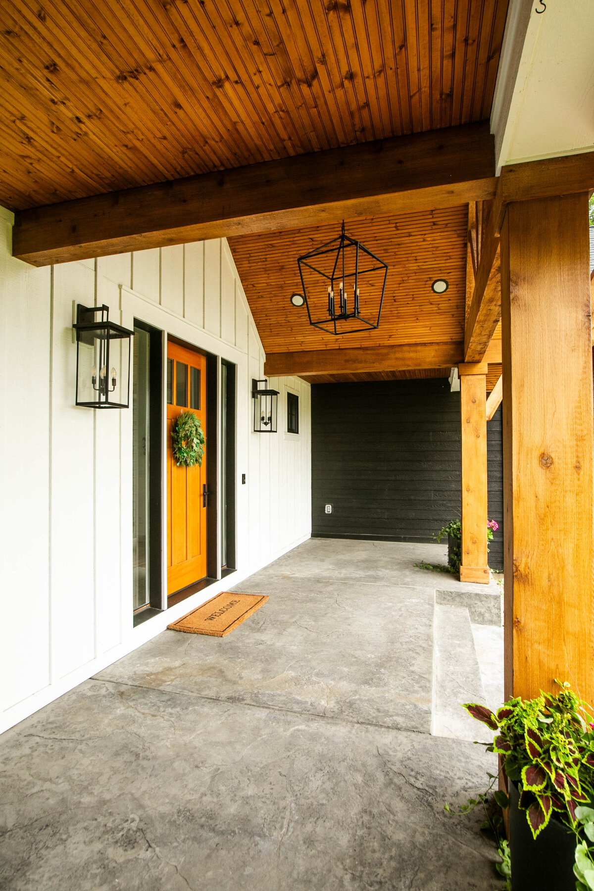 Exterior view of custom home in Otsego, Minnesota with modern wood details and front porch built by Cornerstone Custom Builds