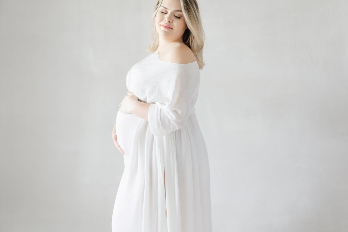 Tampa lifestyle maternity session highlighting glowing mom-to-be Calli on canvas backdrop