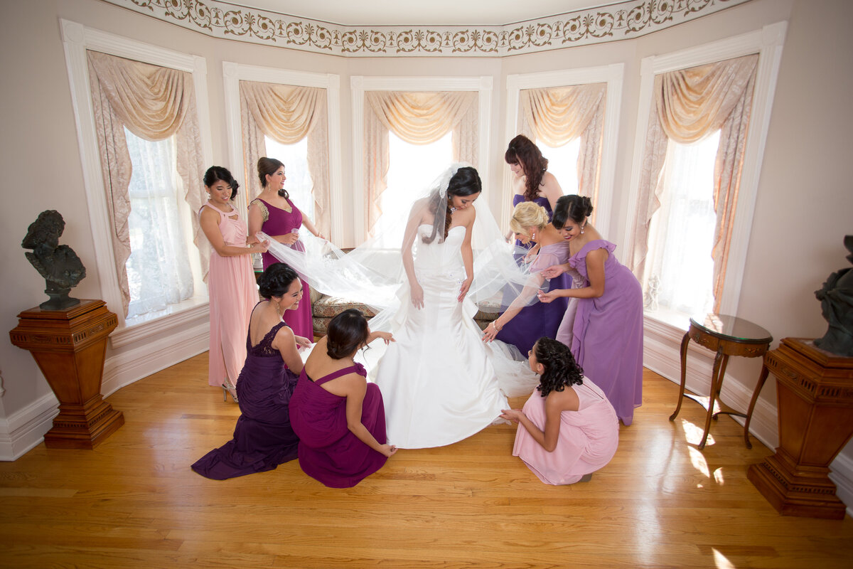 Bridesmaids wearing purple help the bride for a wedding at the Haley Mansion in Joliet, IL.
