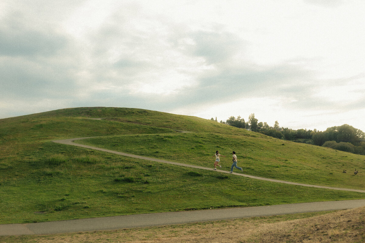 Couple running on the beach during golden hour on Vancouver Island, documented by storyteller Rae Terrillon Photo