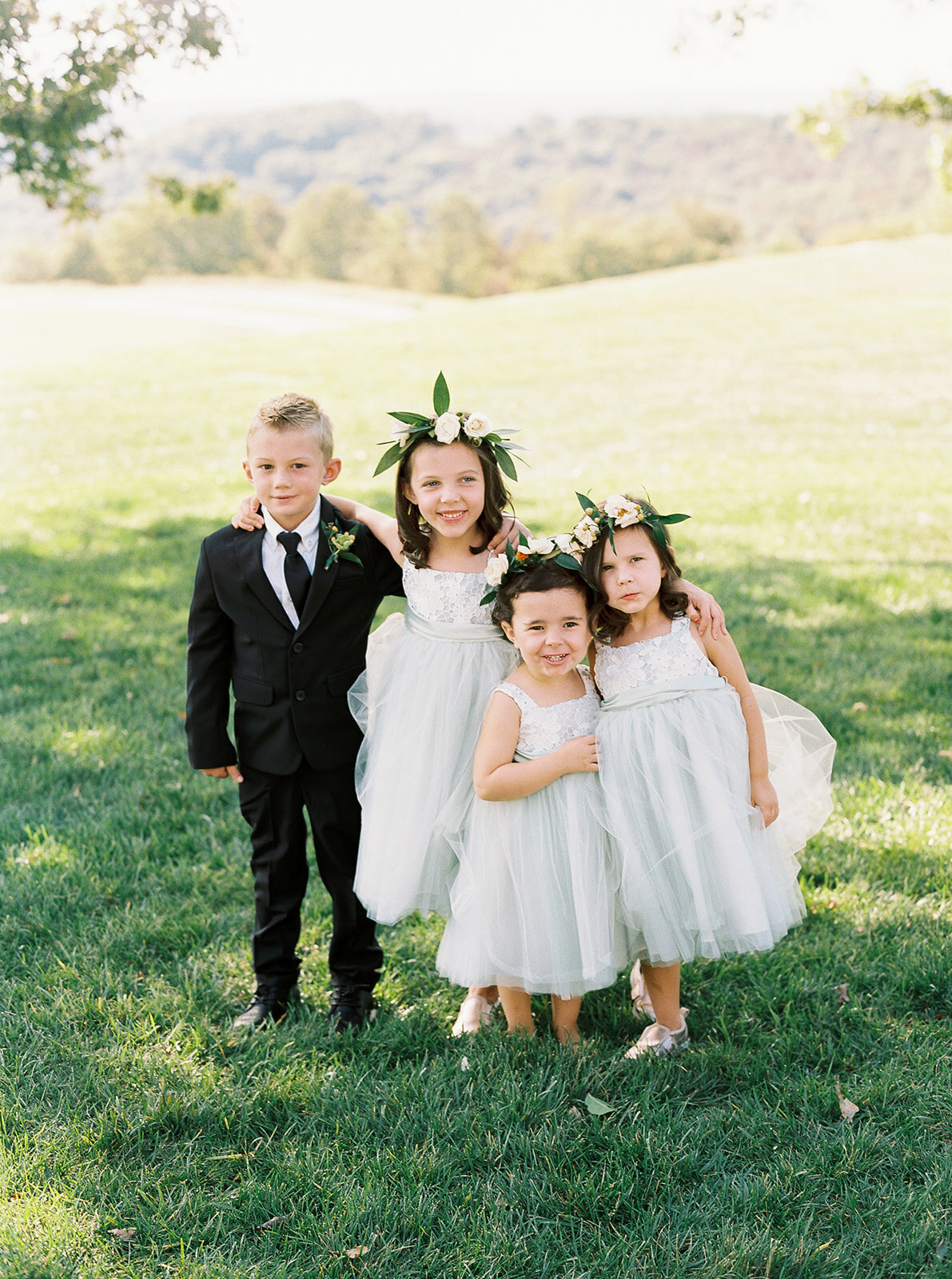 young flower girls and a ring bearer boy standing together