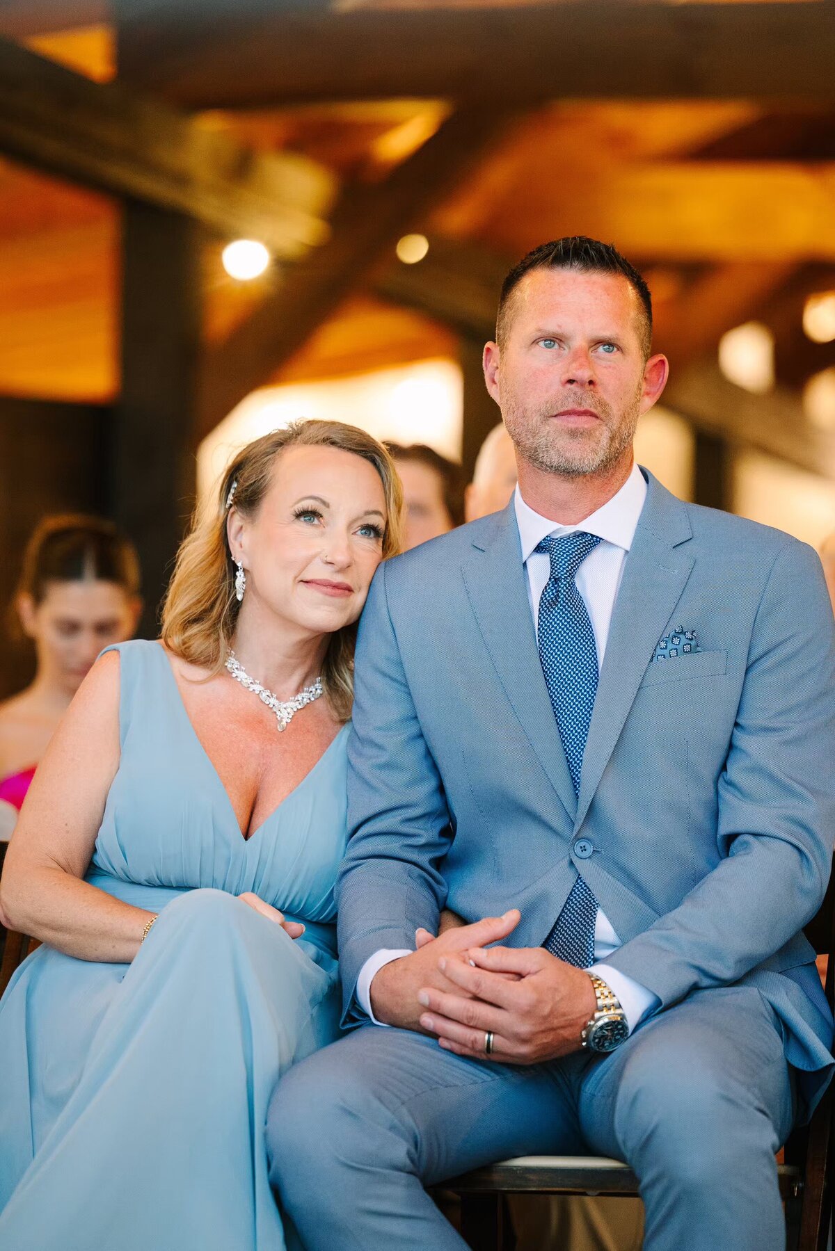 Grooms parents intently watching the wedding ceremony