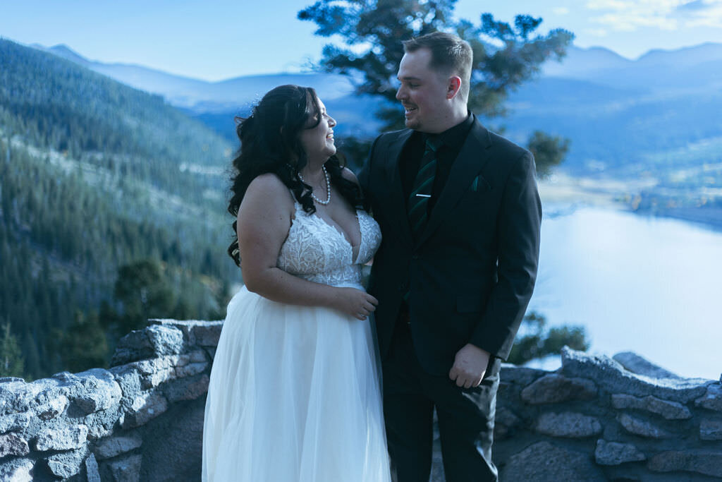 A newlywed couple looking at each other and smiling.