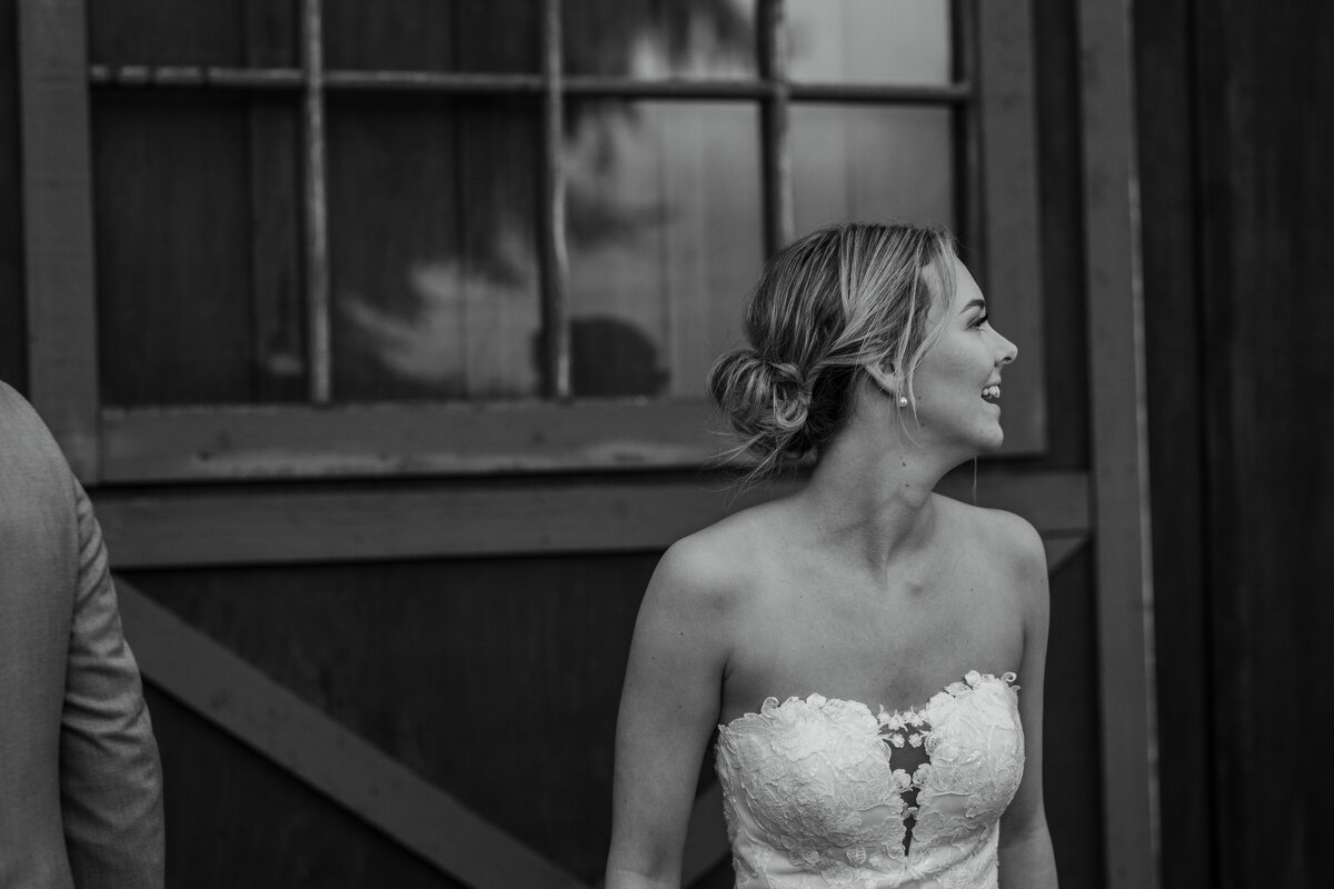 Bride smiling  in front of barn doors