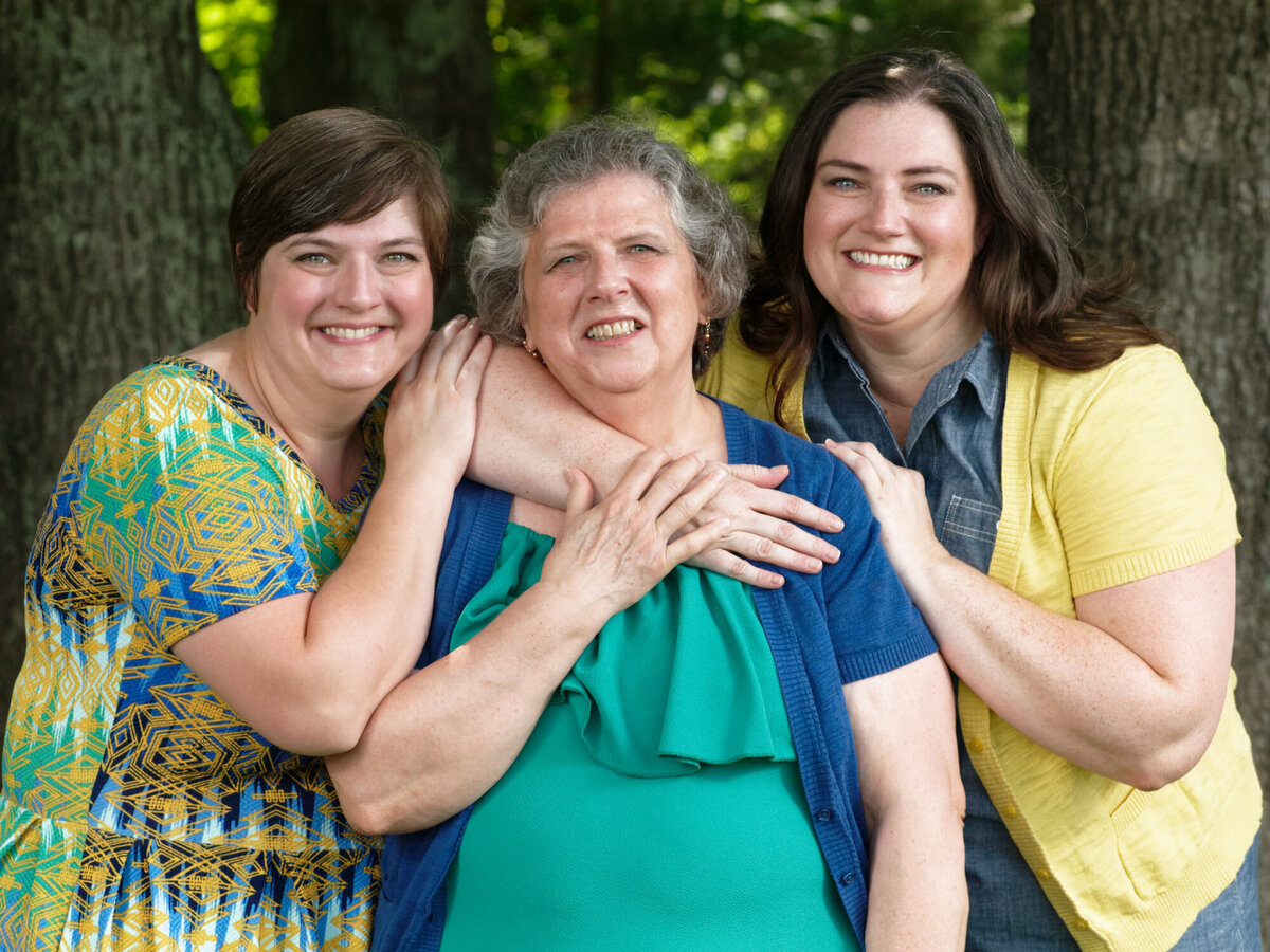 sisters hugging mother outdoor daytime portrait