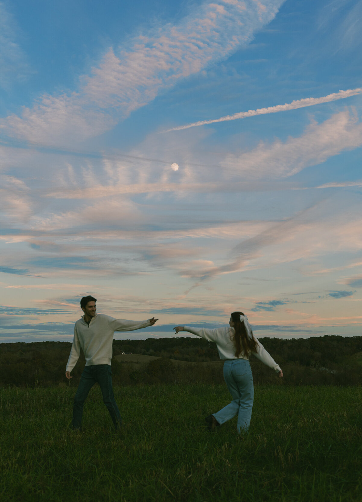 A couple frolics together in a North Georgia meadow.