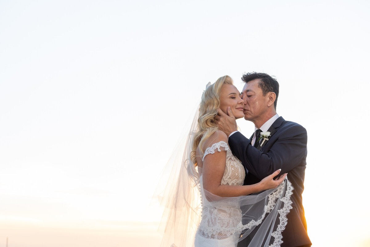 A groom kissing a bride's cheek