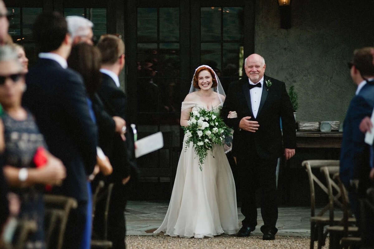 A bride walking down the aisle with her dad.