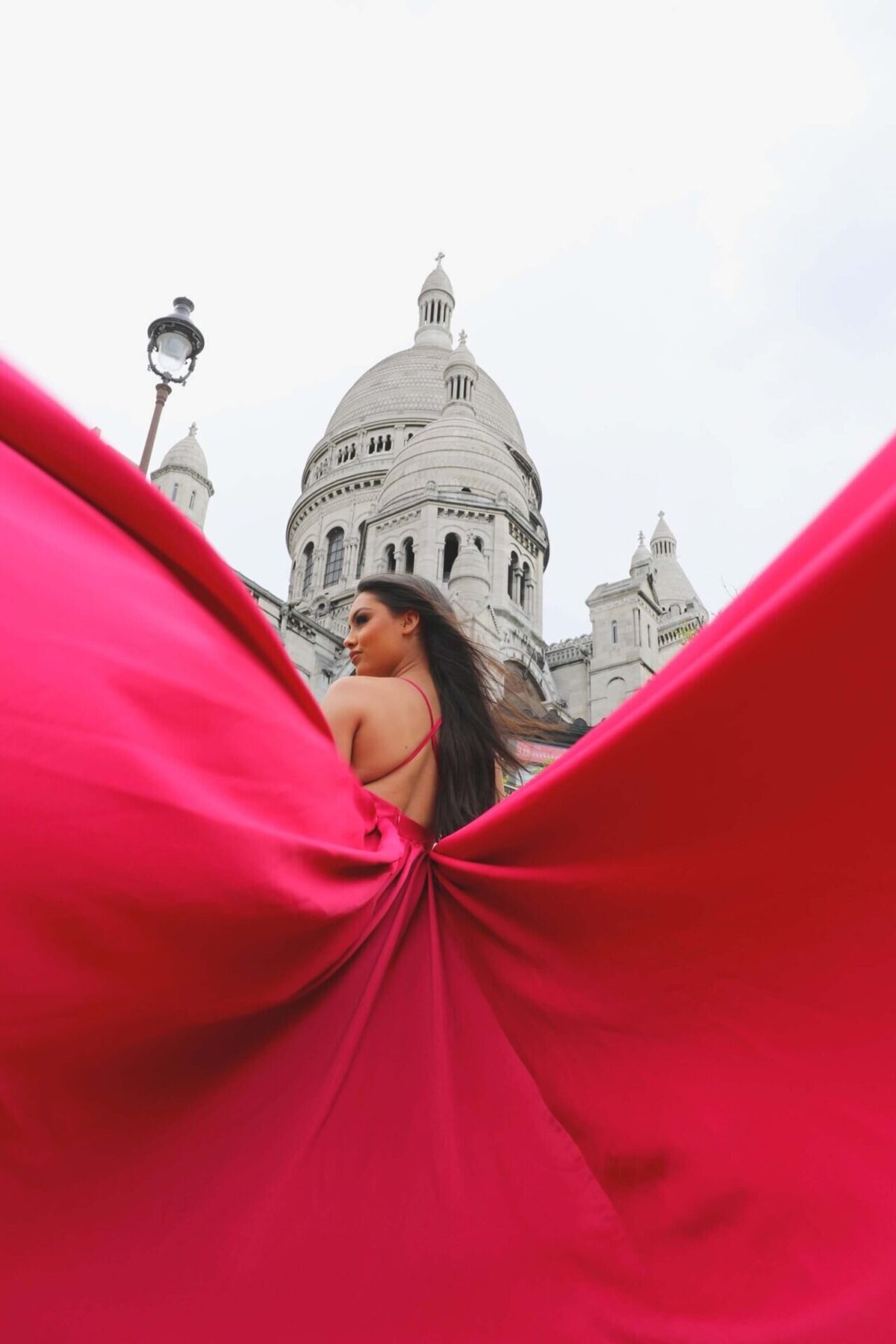 women having a portrait photoshoot in paris wearing a pink flying dress