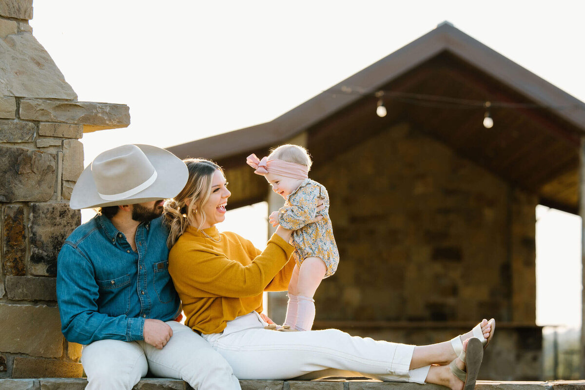 candid portrait of parents playing with toddler during family photo session