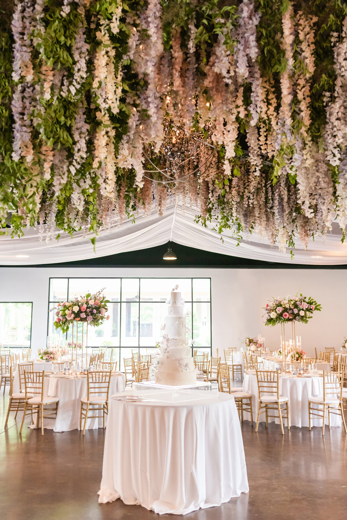 Extravagant wisteria floral installation covers the dance floor at in hues of lavender, cream, dusty pink, and natural greenery. Design by Rosemary and Finch in Nashville, TN.