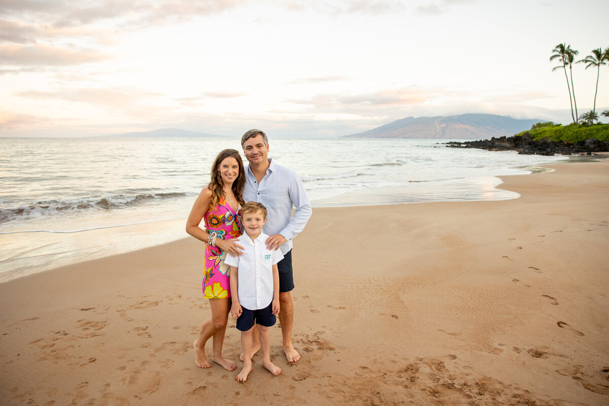 Maui Family Photographers capture young family standing on beach smiling together